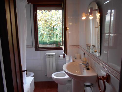 baño con lavabo y aseo y ventana en Apartamentos Los Ánades, en Isla