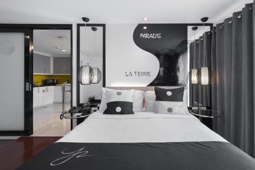 a bedroom with a large bed with black and white pillows at Y2 Residence Hotel Managed by HII in Manila