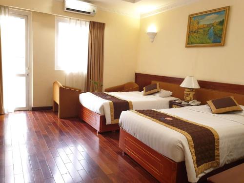 a hotel room with two beds and a window at Huong Sen Hotel in Ho Chi Minh City