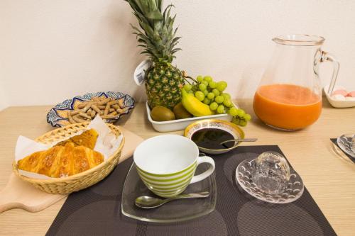 a table with a bowl of fruit and a pitcher of orange juice at Loft & Espace Maison 1706 Lago Orta in Borgomanero