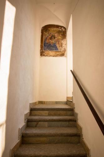 a stairway with a painting and a painting on the wall at Loft & Espace Maison 1706 Lago Orta in Borgomanero