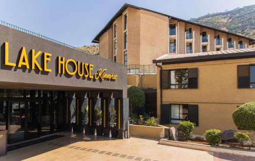 a large building with a lake house cleaners sign on it at Hotel Lake House Kinneret in Tiberias