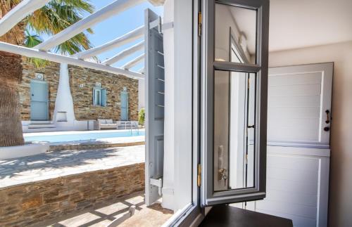 a door leading to a patio with a pool at Onar Hotel & Suites in Tinos Town