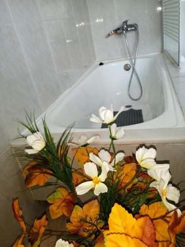a bouquet of flowers sitting in a bath tub at Casa O Rueiro in Esteiro