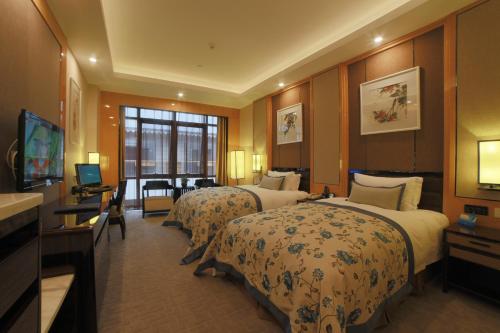 Postel nebo postele na pokoji v ubytování Beijing Yun-zen Jinling Lotus Hotel