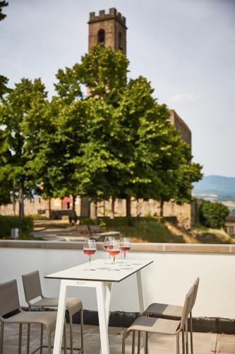 a white table with wine glasses on a balcony at Poppi Suites in Poppi