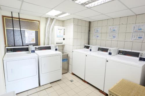 eine Waschküche mit vier Waschmaschinen und einer Reihe davon in der Unterkunft Park Lane Inn in Taichung