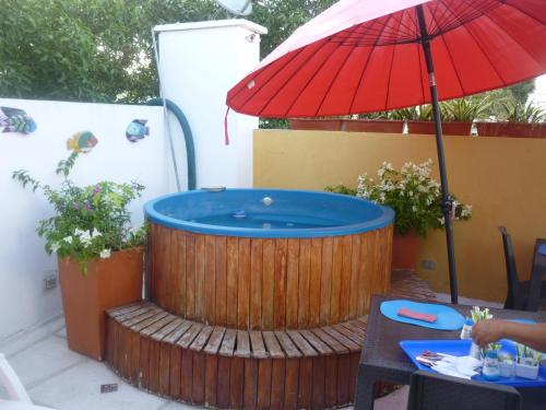 a hot tub on a deck with a red umbrella at Zana Hotel Boutique in Cartagena de Indias