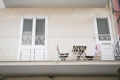 a white balcony with chairs and windows at Ludovica Home in Giardini Naxos