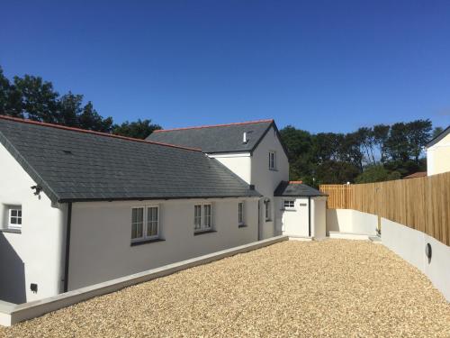 a white house with a gravel driveway at Sunnyside Barn in Truro
