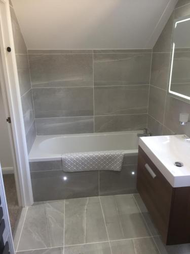 a bathroom with a bath tub and a sink at Sunnyside Barn in Truro