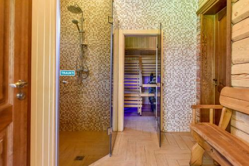 a bathroom with a walk in shower and a hallway at Auksinis Ąžuolas in Avižieniai