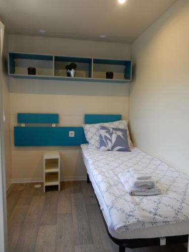 ein kleines Schlafzimmer mit einem Bett und blauen Regalen in der Unterkunft Tiny house Dora in Marčana