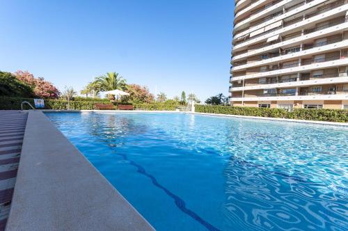 a large swimming pool next to a tall building at AG SAN PAULO PREMIUM in Playa de Gandia
