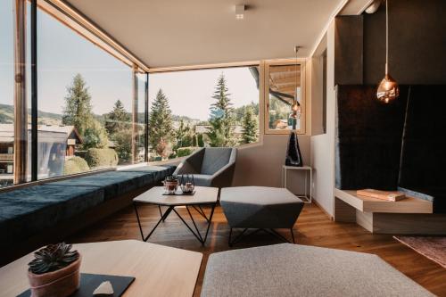 a living room with a couch and a large window at Alpina Wagrain in Wagrain