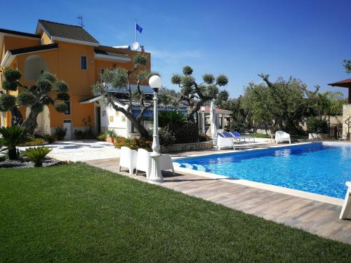 una villa con piscina di fronte a una casa di Villa Iris a Castellana Grotte