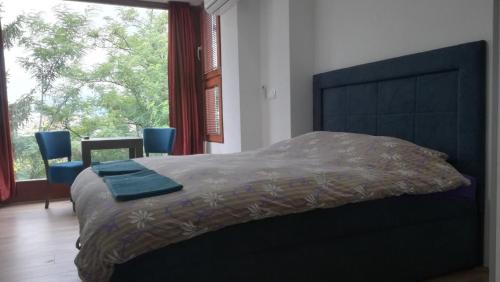 a bedroom with a large bed and a large window at Beautiful View Of Sarajevo Center in Sarajevo