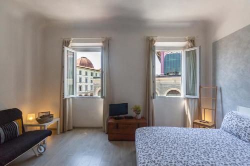 1 dormitorio con 1 cama y 2 ventanas en Piazza del Mercato Centrale, en Florencia