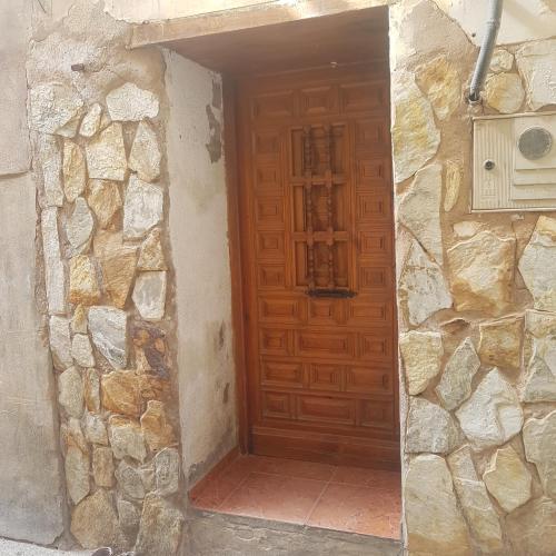 a wooden door in a stone building with a stone wall at Apartamento CabezoDoce in Calahorra