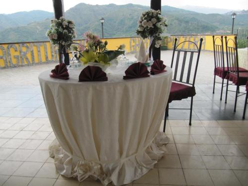 a table with a white table cloth and flowers on it at Agriturismo Ghiritina in Francavilla di Sicilia