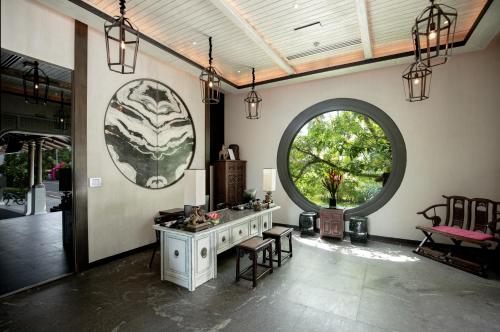 a living room with a table and a large window at Baba Beach Club Natai Luxury Pool Villa Hotel by Sri panwa - SHA Plus in Natai Beach