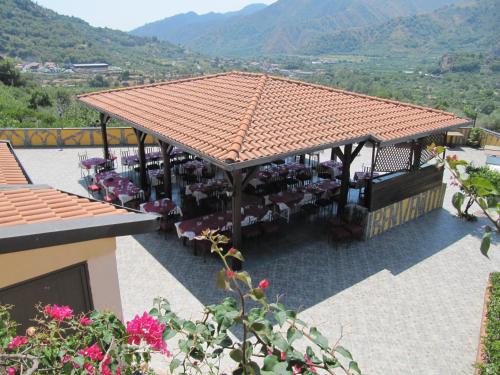 a restaurant with a roof with tables and chairs at Agriturismo Ghiritina in Francavilla di Sicilia