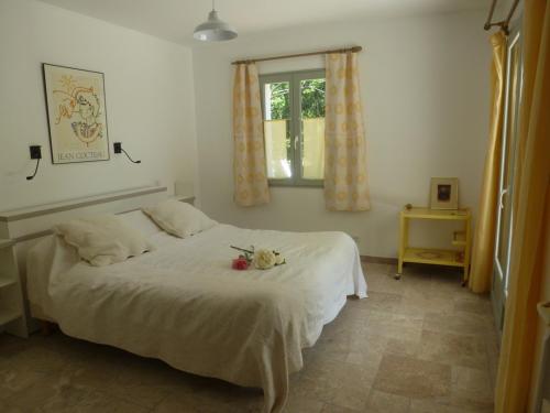 ein Schlafzimmer mit einem weißen Bett und einem Fenster in der Unterkunft LE COTTAGE in Ailhon