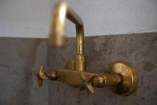 a brass faucet attached to a wall at Kruthuset in Visby