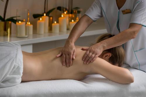 a woman getting a massage from a therapist at Akacja Medical Resort in Ciechocinek