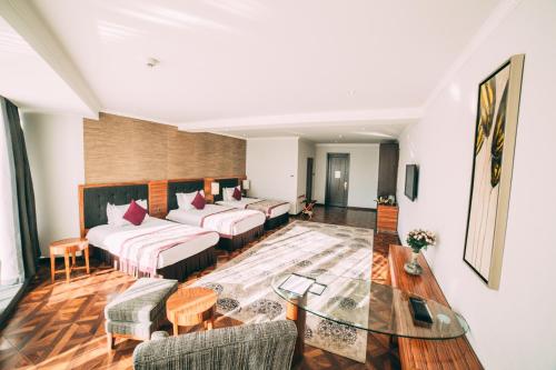 a living room with couches and a glass table at Damas International Hotel in Bishkek