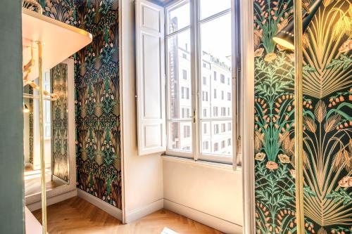 Cette chambre dispose d'une fenêtre et de papier peint à fleurs. dans l'établissement Glance in Rome, à Rome