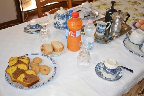 a table with plates of food and bottles of orange juice at LE PIUME B&B in Cupramontana