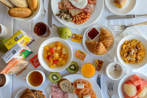 un tavolo con molti piatti di cibo sopra di Hotel Apartamentos Vibra Lux Mar a Ibiza Città