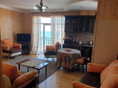 ein Wohnzimmer mit Tisch und Küche in der Unterkunft Apartment with sea view 37 in Kobuleti