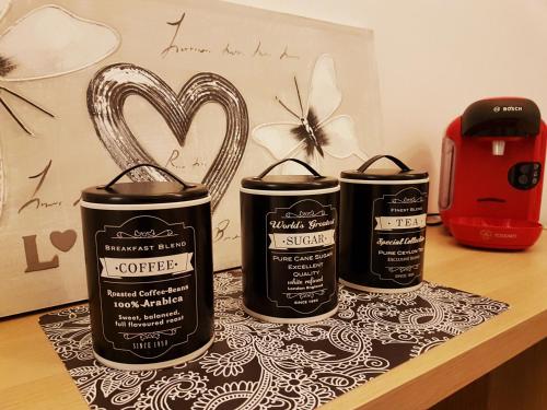three cans of coffee sitting on a table with a heart at SW Cosy Apart - Chambly Persan Roissy in Persan