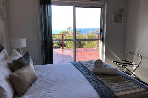 a bedroom with a bed with a view of the ocean at BAY OF FIRES SEACHANGE Ocean frontage in Binalong Bay