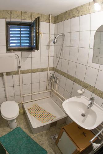 a bathroom with a sink and a tub and a toilet at Vikendica MM in Zlatibor