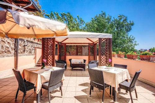 a patio with tables and chairs and an umbrella at Hotel Roma Tiburtina Metro in Rome
