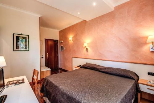 a bedroom with a bed and a table and a desk at Hotel Roma Tiburtina Metro in Rome