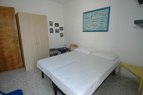 sypialnia z białym łóżkiem i obrazem na ścianie w obiekcie Residence Trande w mieście Leuca