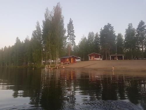 een groep hutten met uitzicht op een meer bij Camping Atrain in Kuopio