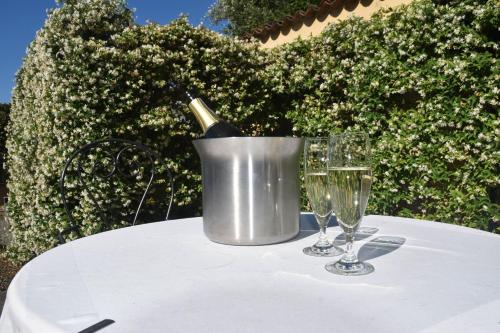 a bottle of wine in a bucket on a table with two glasses at Best Western Plus Hotel Le Rondini in San Francesco al Campo