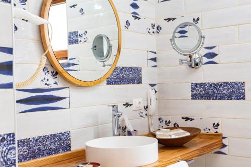 een badkamer met blauwe en witte tegels en een spiegel bij Suna Sun Hotel - Adult Only in Kas