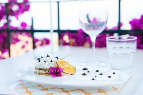 a white plate with a pastry on a table with a glass at Hotel Villa Taormina in Taormina
