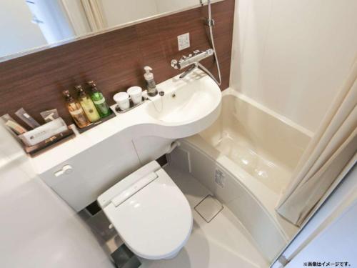 a bathroom with a toilet and a sink and a tub at HOTEL LiVEMAX Nihonbashi Ningyocho in Tokyo