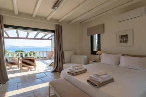 Therme Sea Luxury Lodge في Thermisía: غرفة نوم عليها سرير وفوط