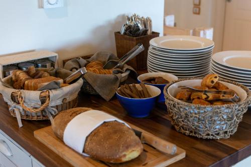 a table topped with baskets of bread and plates at Therme Sea Luxury Lodge in Thermisia
