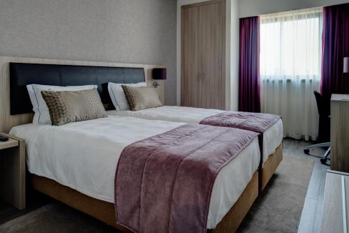 um quarto com uma cama grande em um quarto de hotel em VIP Inn Berna Hotel em Lisboa