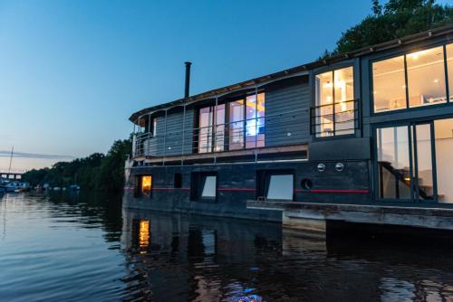 une maison sur un bateau dans l'eau dans l'établissement La Rivière House - Péniche Carpe Diem, à Nantes