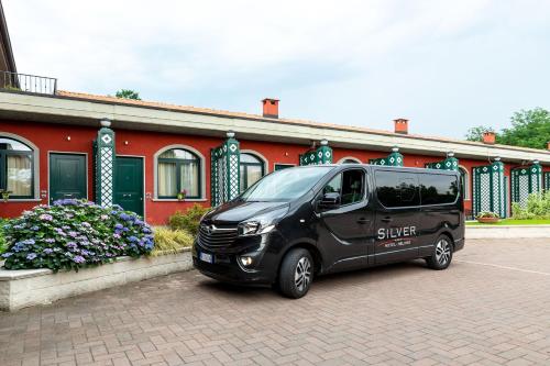 a black van parked in front of a red building at Hotel Silver Milano in Milan